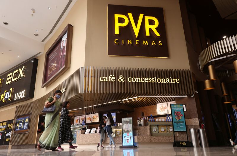 Women walk outside a PVR movie theatre in Mumbai