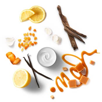 Skincare product ingredients displayed: lemon slices, vanilla beans, orange peel, cinnamon sticks, garlic cloves, and caramel syrup