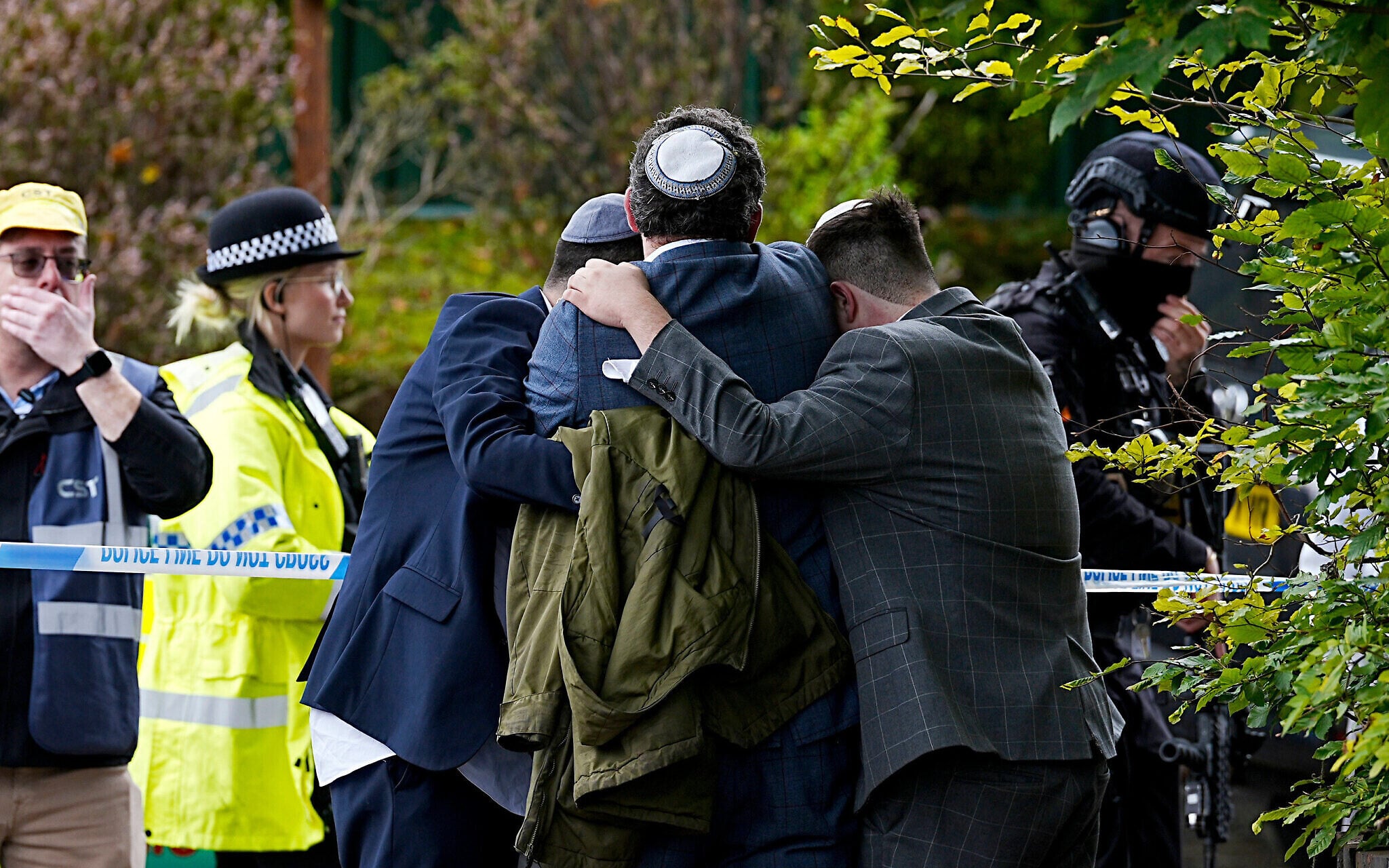 Members of the Jewish community comfort each other following a deadly terror attack during Yom Kippur services at the Heaton Park Hebrew Congregation synagogue in Crumpsall, Manchester, northern England, October 2, 2025. (Peter Byrne/PA via AP)