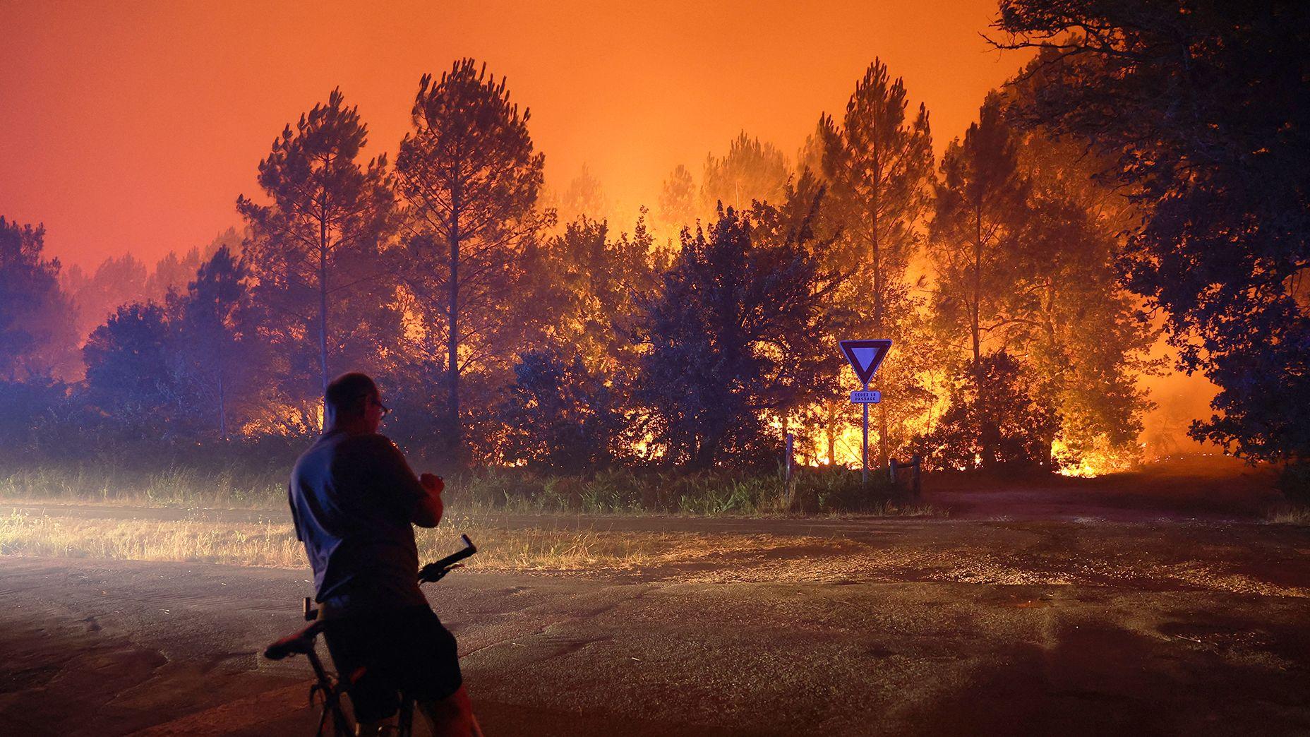 A resident looks at the approaching wildfire in Le Porge, south-west France