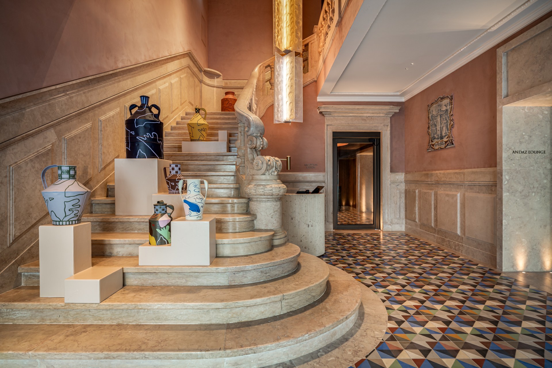 Ceramics and artwork lining the staircase in the lobby at Andaz Lisbon.