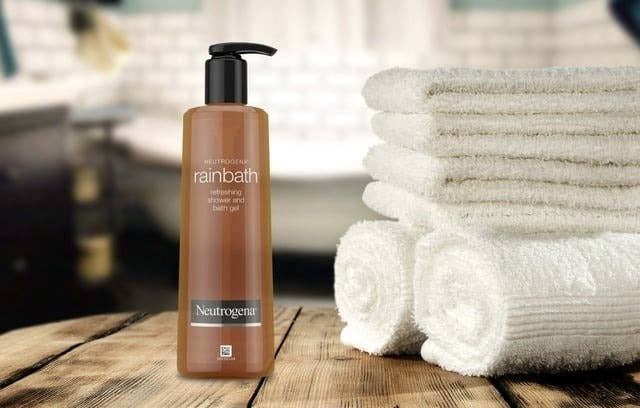 Neutrogena Rainbath shower gel on wooden surface with clean towels in background