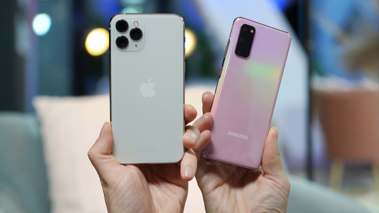 Two hands holding an iPhone 11 Pro and Samsang Galaxy S20