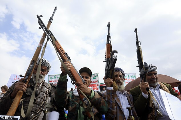 Pictured: Houthi supporters hold up their weapons during a protest against Saudi Arabia
