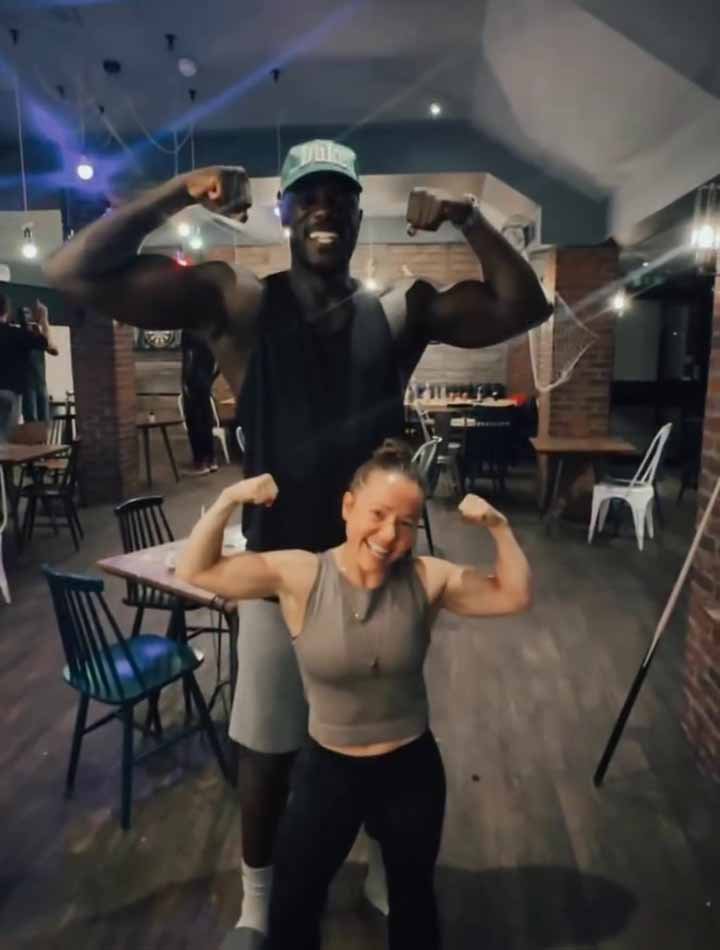 Stuntwoman Devyn Dalton poses with another stunt performer over seven feet tall behind her