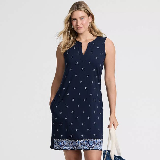 Person in a sleeveless patterned dress holding a bag, suitable for casual outings