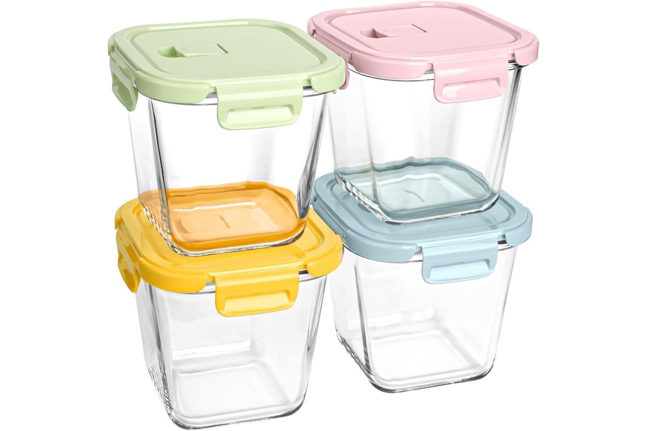 Four glass food storage containers with pastel lids stacked in two rows