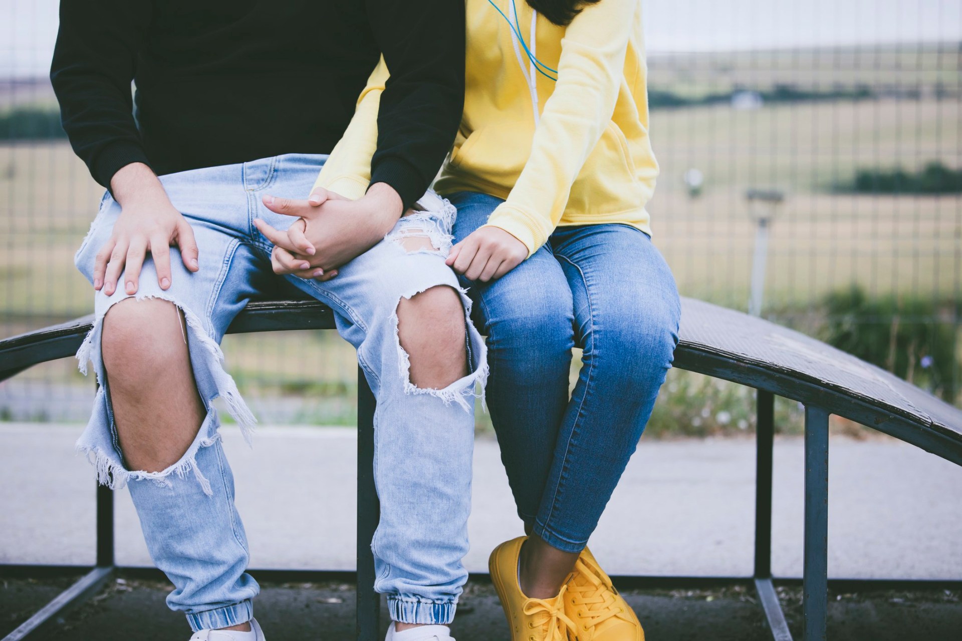 Young teenage couple holding hands in a public park.