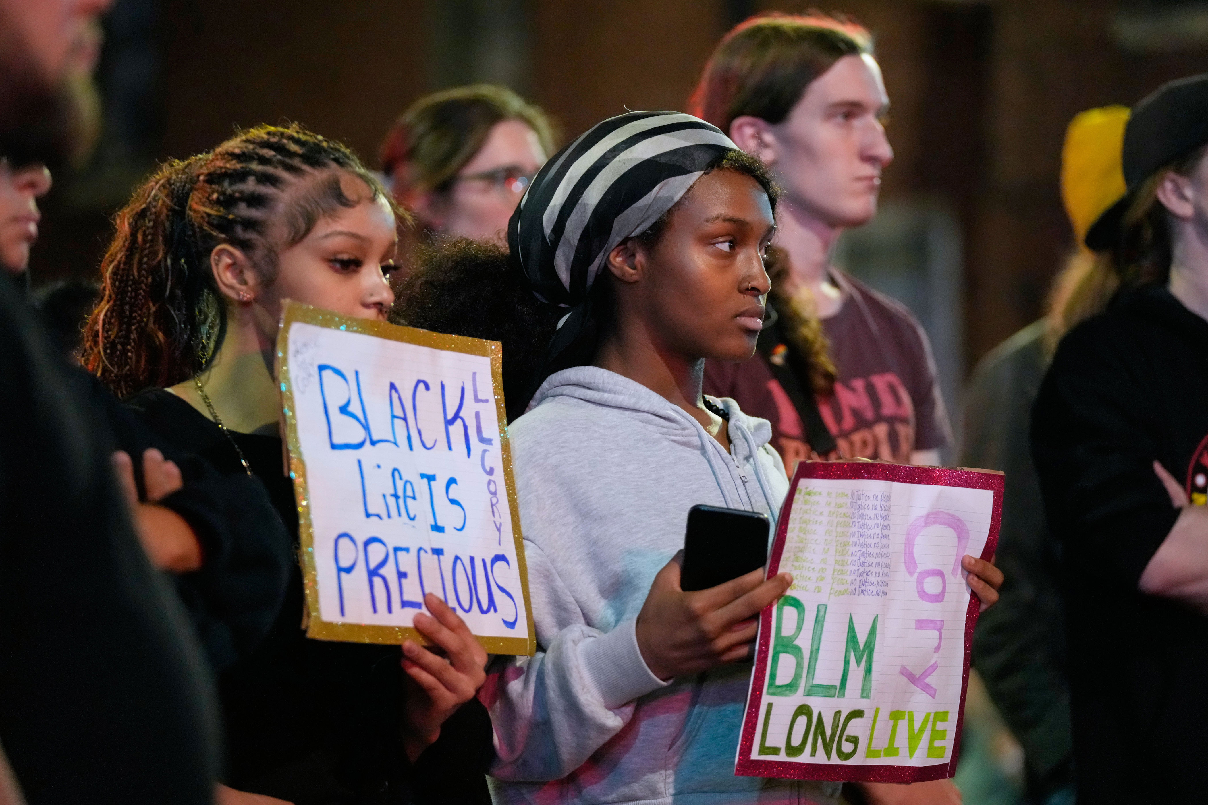 Protesters gather at a candlelight vigil for the victim Wednesday evening (AP)