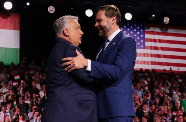 TOPSHOT - US Vice President JD Vance (R) and Hungarian Prime Minister Viktor Orban shake hands on stage during a