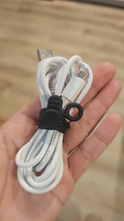 a hand holding a wire using the cable organizer