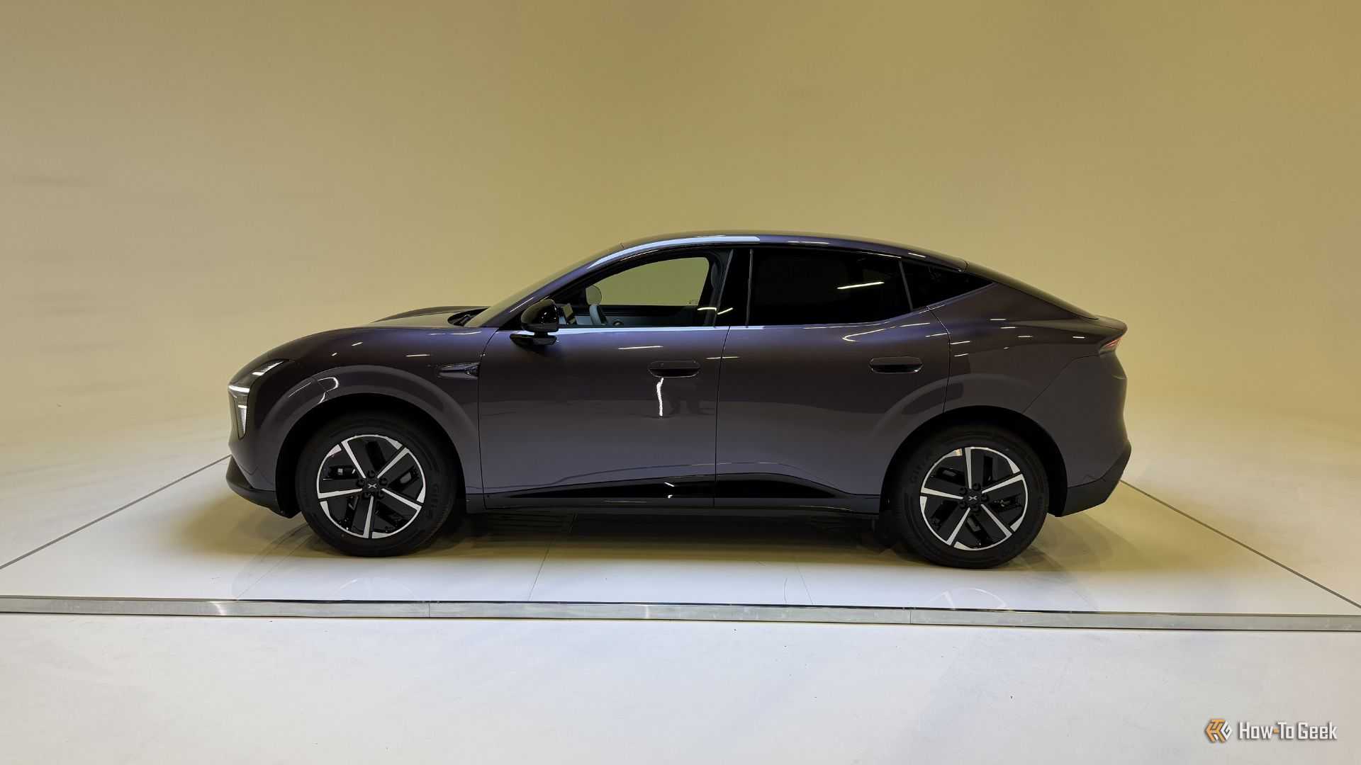 Static side profile shot of a purple XPENG L03 in a studio.