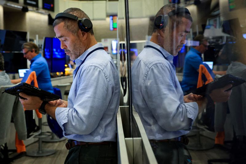 FILE PHOTO: Traders work on the floor of the NYSE in New York