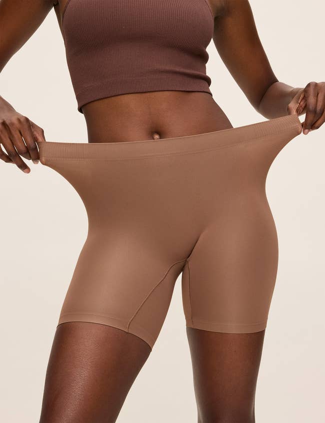 Person wearing seamless, high-waisted sheer shorts and a ribbed crop top
