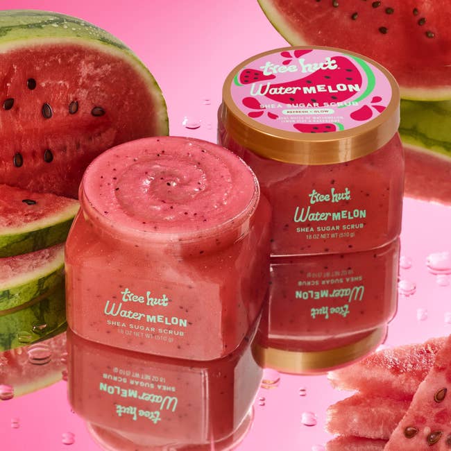 Tree Hut Watermelon Shea Sugar Scrub jars surrounded by fresh watermelon slices on a reflective surface