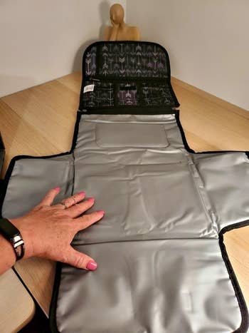 Hand placing lunch bag liner with utensil holder on a wooden table