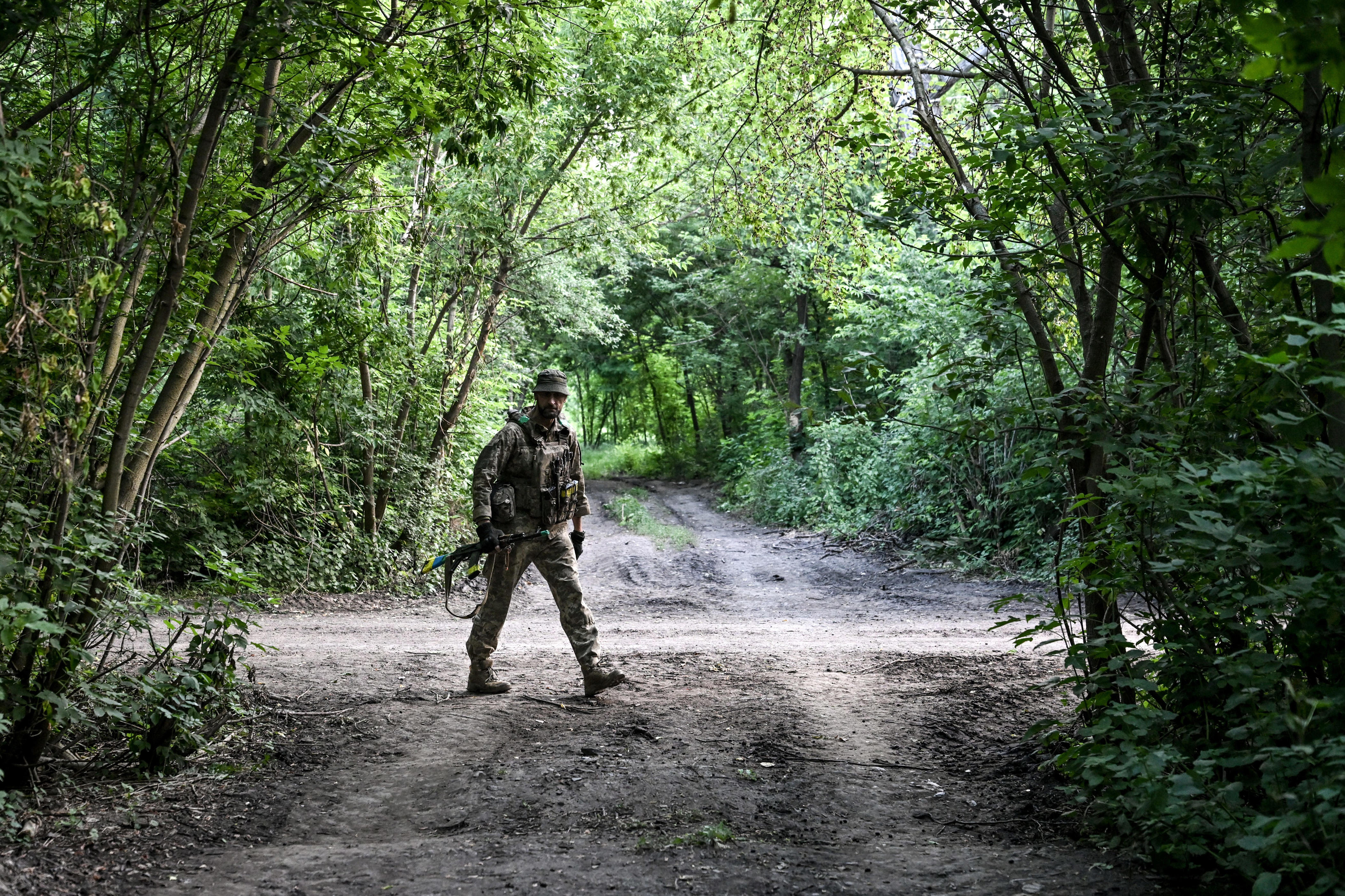 A soldier from the 148th Separate Artillery Zhytomyr Brigade of the Ukrainian Airborne Forces walks along the road as he prepares for a combat deployment to a firing position in the Dnipropetrovsk region, Ukraine, on June 22, 2026.