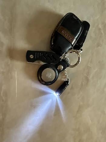 Keychain with a flashlight emitting light, attached to a car remote