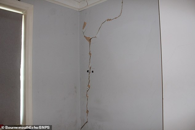 The shop, which is owned by The Nero Group, has agreed to a repairs plan on a no-fault basis but no start date has been confirmed (Pictured: A crack in one of the homes above the shop)