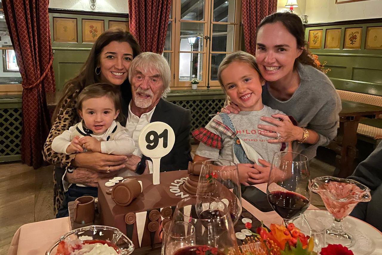 Tamara Ecclestone and Bernie Ecclestone seated together in a family gathering with children present and a celebrationthemed setting