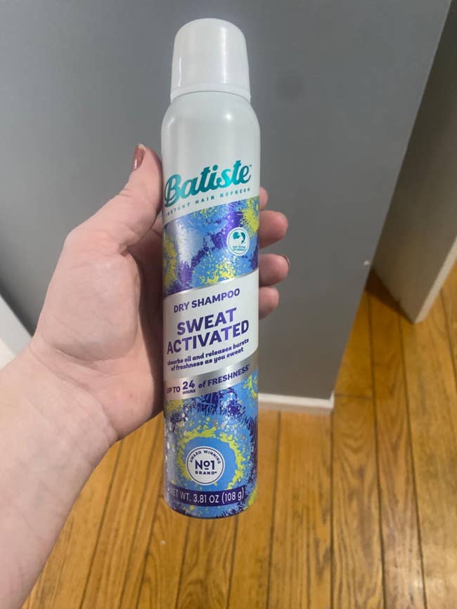 Hand holding Batiste dry shampoo bottle labeled