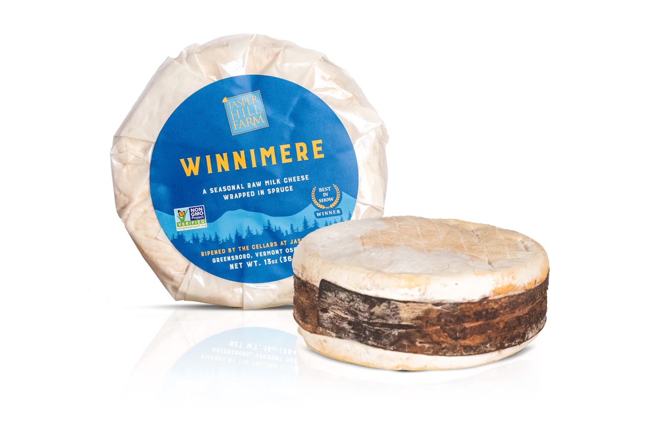 Wheel of Winnimere cheese one wrapped in packaging and one unwrapped