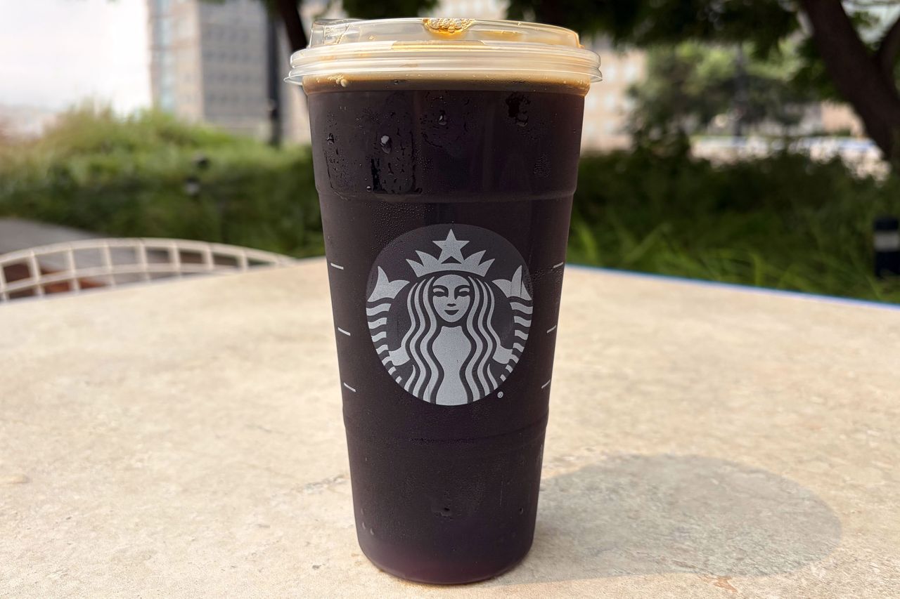 A Starbucks cup filled with a cold brew coffee placed on an outdoor table