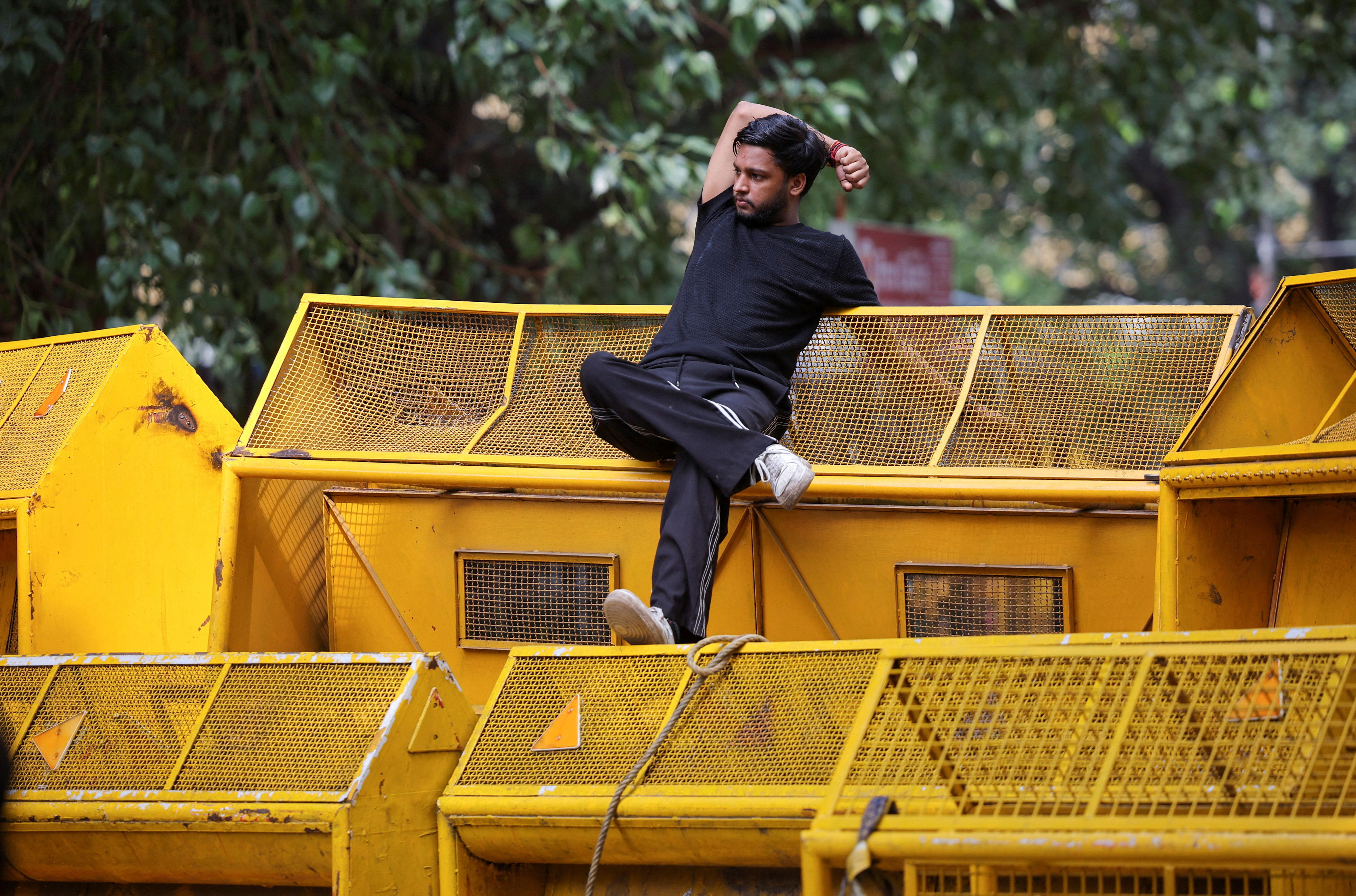 A supporter of India's Cockroach Janata Party (CJP) rests on a barricade during the ongoing protests (Reuters)