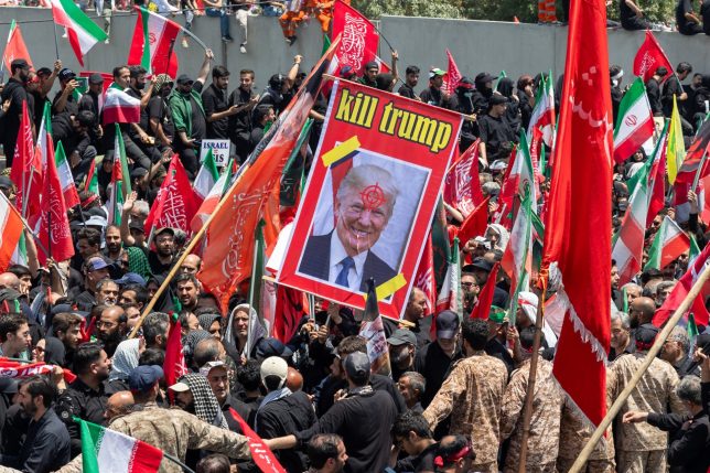 TEHRAN, IRAN - JULY 6: A poster with the slogan 'Kill Trump' is displayed as mourners gather to pay final respects to Iran's slain Supreme Leader Ayatollah Ali Khamenei during the third day of his funeral ceremonies on July 6, 2026 in Tehran, Iran. Khamenei and members of his family were killed on February 28 during U.S.-Israeli strikes at the beginning of the war, bringing an end to his 36-year rule over Iran. A multi-city state funeral will be held over six days before his body is laid to rest on July 9, in his hometown of Mashhad, Iran. (Photo by Majid Saeedi/Getty Images)