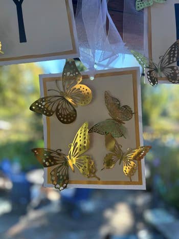 close up for four stick on gold butterflies in different shapes stuck to a party decoration