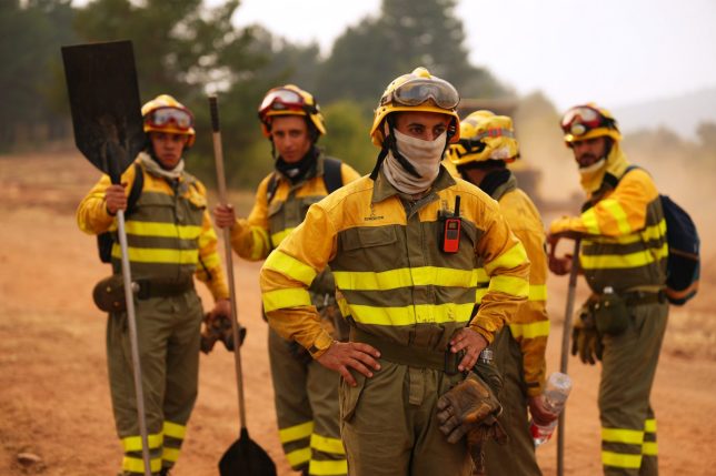Forest rangers take a break before returning to work on the fire near Condemios de Arriba, Guadalajara province, Spain, Wednesday, July 22, 2026, after a wildfire scorched tens of thousands of hectares in one of Spain's largest wildfires in recent years. (AP Photo/Manu Fernandez)