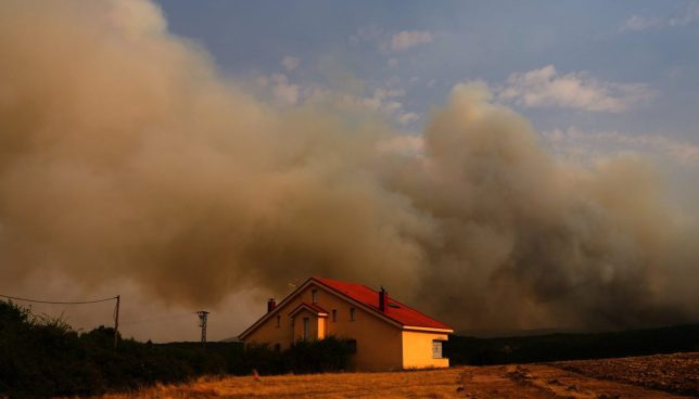 Smoke rises above the horizon as wildfire advances near Condemios de Arriba, Guadalajara province, Spain, Wednesday, July 22, 2026, after a wildfire scorched tens of thousands of hectares in one of Spain's largest wildfires in recent years. (AP Photo/Manu Fernandez)