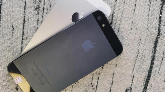 An iPhone 5 in Black and Slate; the phone is colored gray in the middle while the top and bottom are black