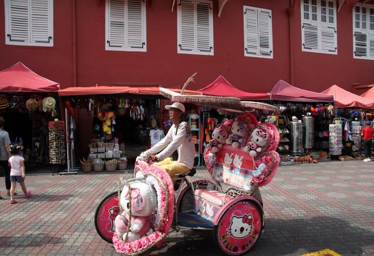A trishaw passes by heritage buildings in Melaka in January 2024. Photo: John Brunton