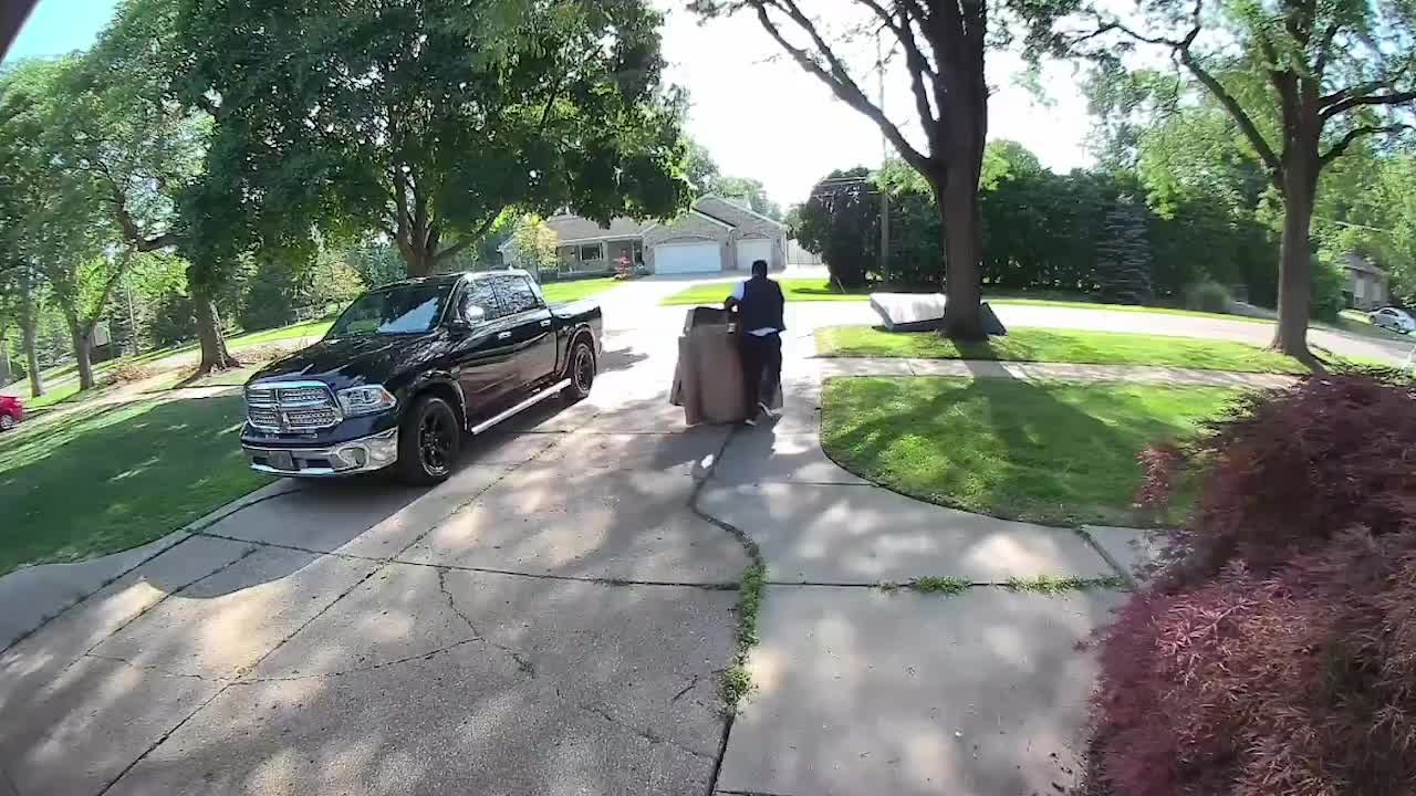 Man trips while carrying stack of cardboard boxes
