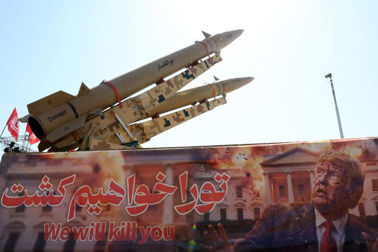 Iranian missiles on display above a banner depicting US President Trump at Azadi Square in Tehran