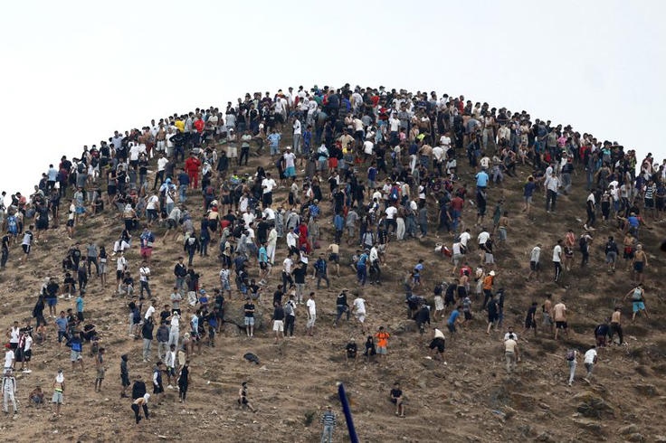 People gather on a hilltop close to the site of clashes near Fnideq, on the Morocco-Spain border, on July 31, 2026