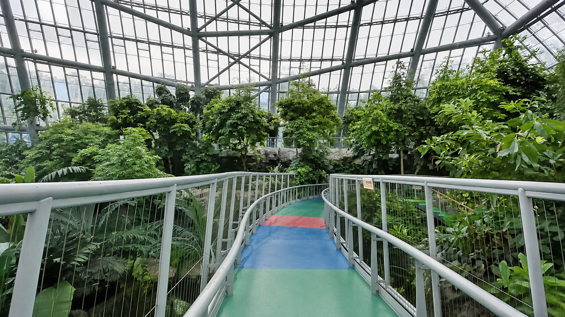 Glass dome encloses a multi-level tropical botanical landscape inside