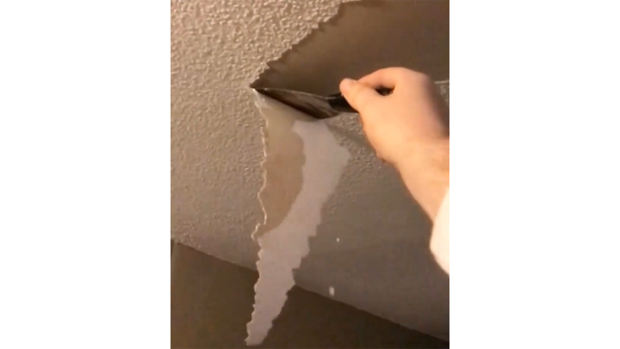Scraping popcorn ceiling texture creating smooth surface for fresh ...