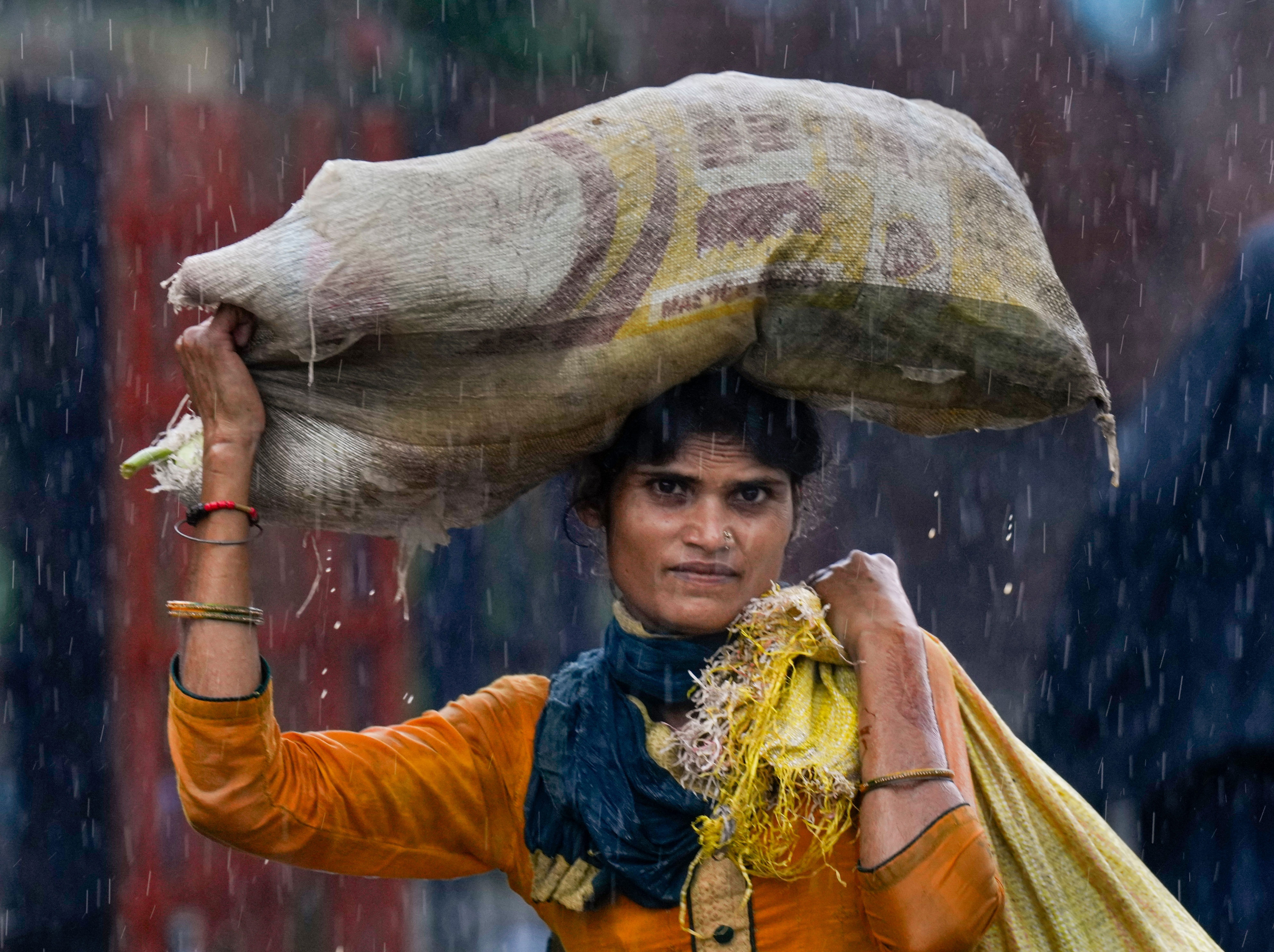 A woman wades through a waterlogged road amid rainfall in New Delhi. (Photo: PTI)