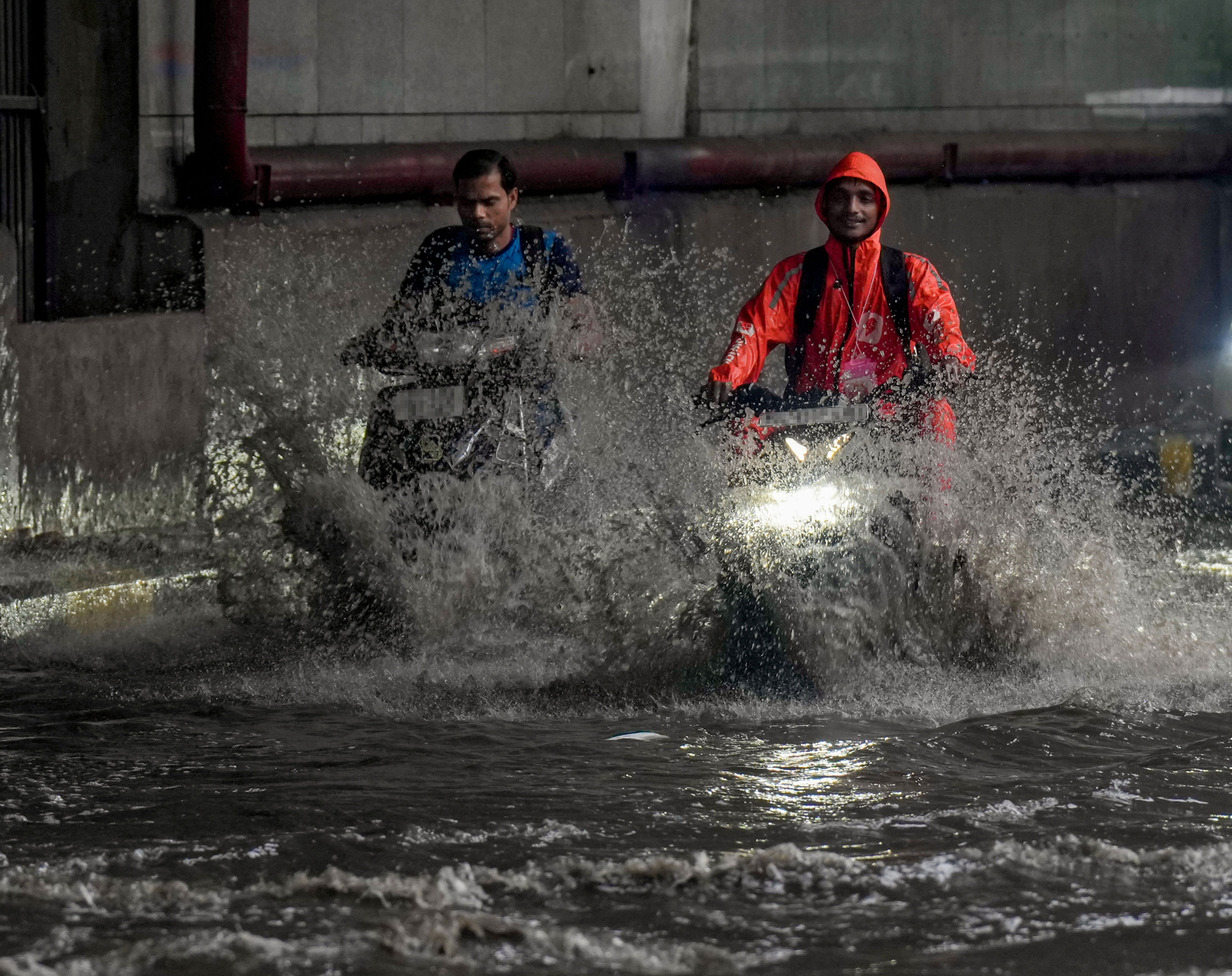 Commuters move on a waterlogged road amid rain. (Photo: PTI)