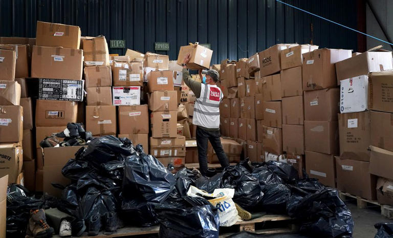 A Care4Calais worker stacks up boxes of freebies ready to hand to would-be migrants in France | Source: PA