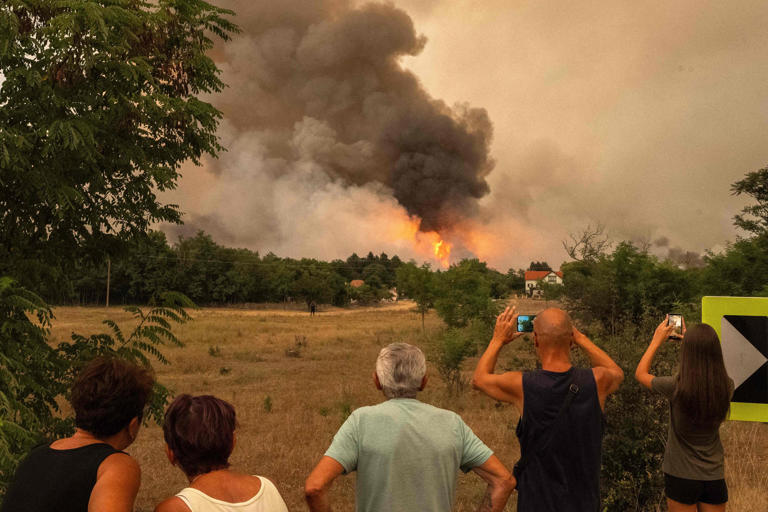 On the 7th, residents look at smoke rising from wildfires at the Deliblato Sands near Šumarak village, approximately 70 km northeast of Serbia's capital Belgrade. /AFP-Yonhap
