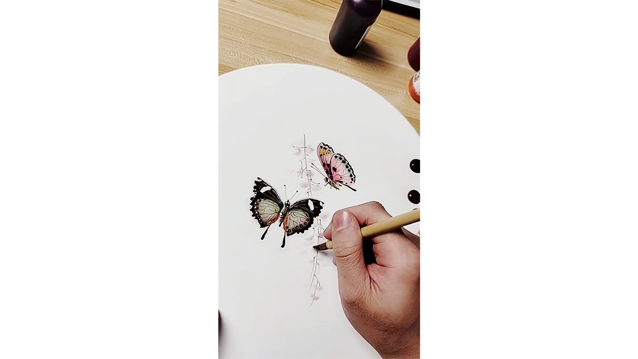 Drawing delicate butterflies with colored ink, creating elegant nature ...