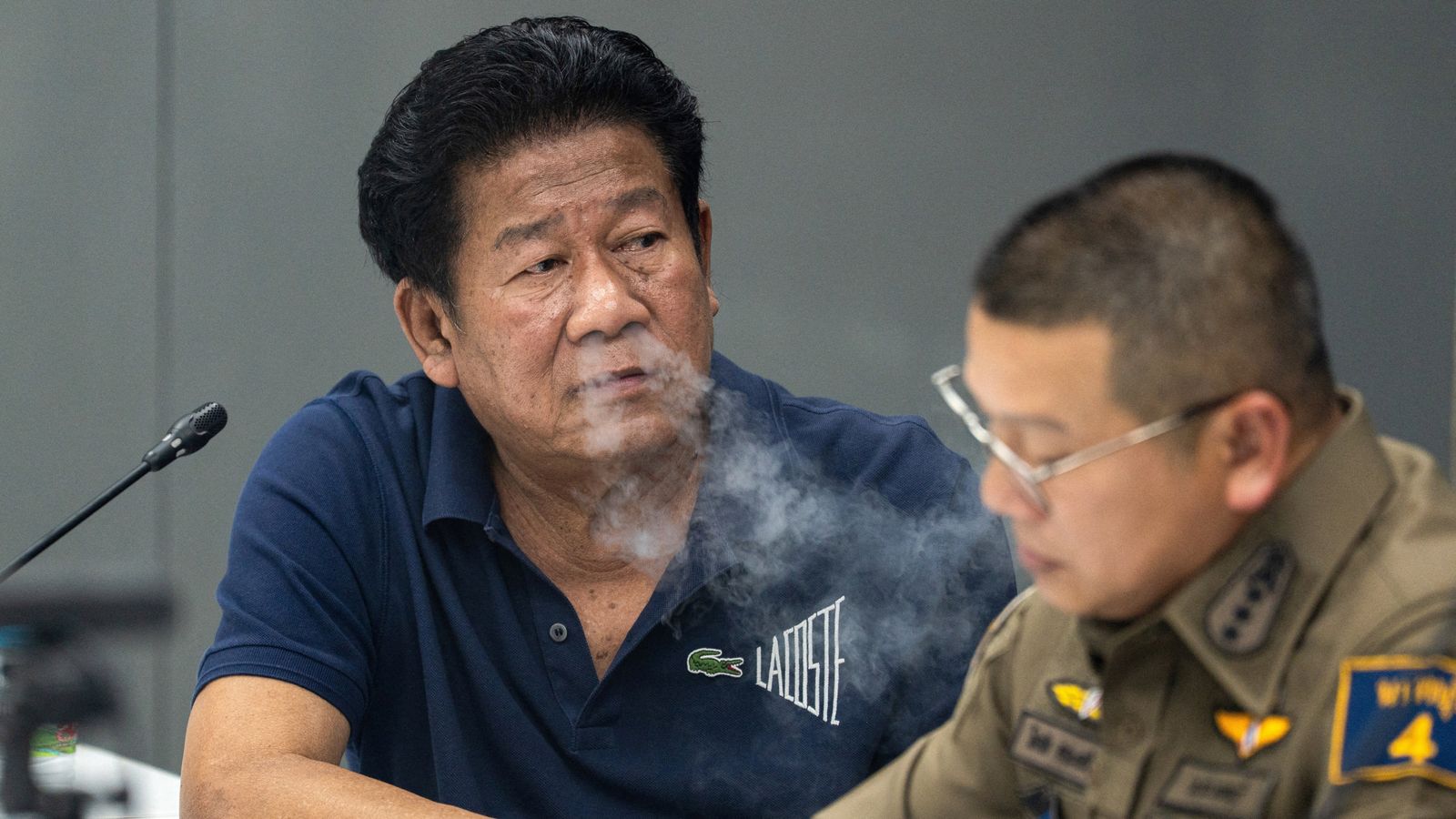 Chalong Riewrang (L) is questioned by police after he allegedly shot and killed Thongchai Yenprasert. Pic: Reuters