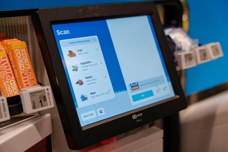 Close-up of a self-checkout touchscreen displaying product categories and scan options.