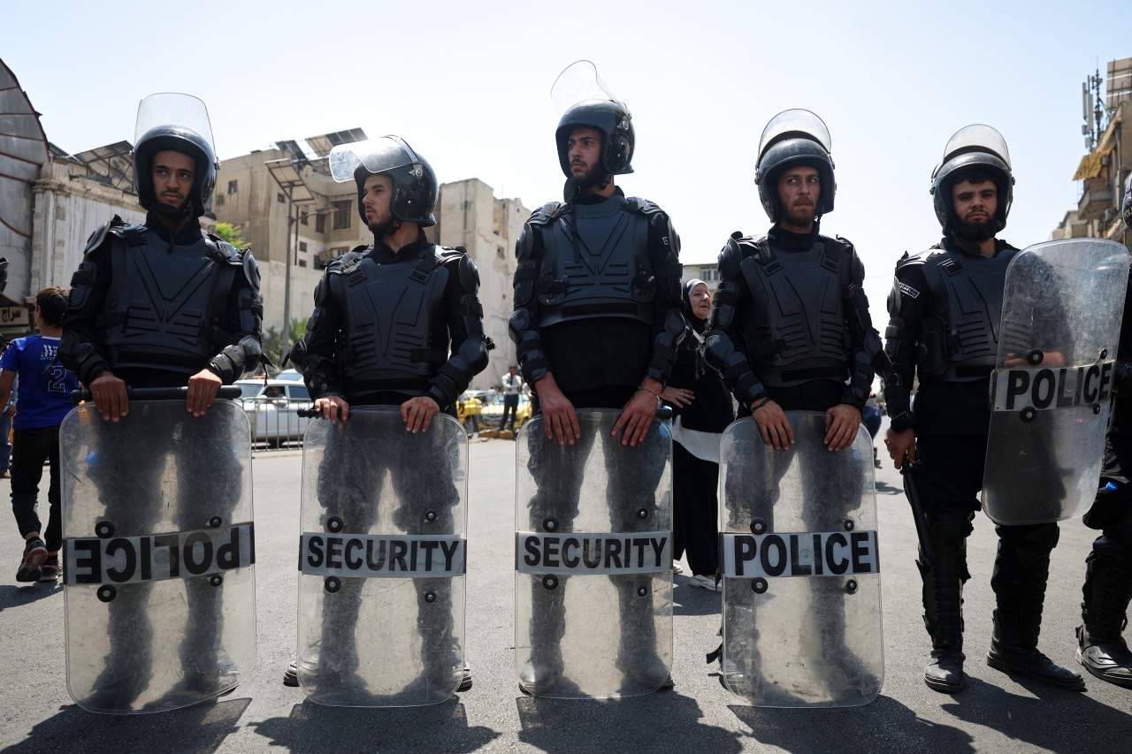 Police stand guard outside a court hearing in which Atef Najib was sentenced to death.