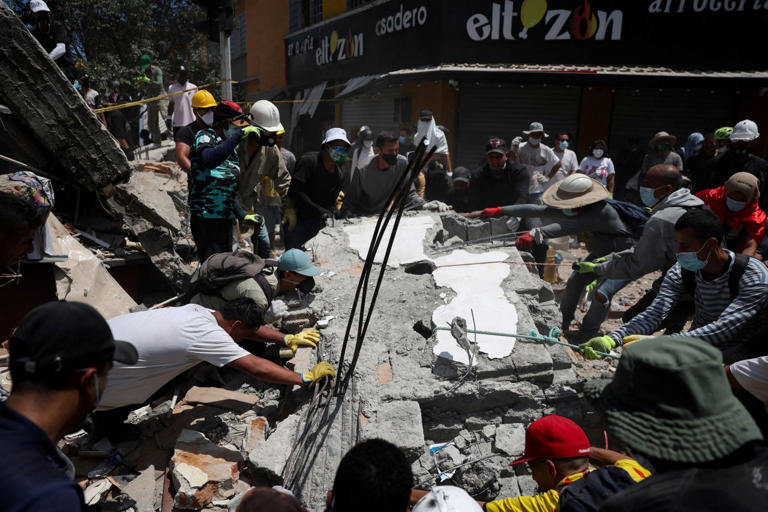 Rescue teams in Colombia dig through rubble to pull out quake victims