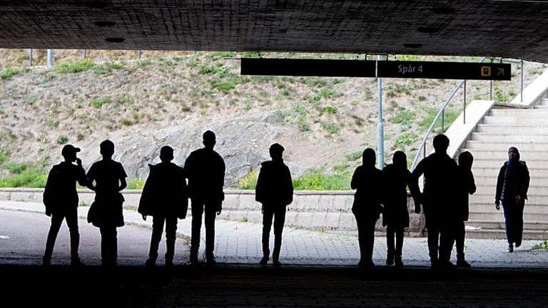 Migrants walk under a railway bridge in the town of Flen, roughly 100 kilometres west of Stockholm, Sweden, 30 August, 2018. AP