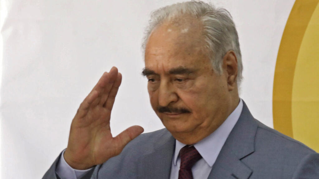 Libya's eastern military chief Khalifa Haftar waves after a speech at the local headquarters of the High National Election Commission in Benghazi on November 16, 2021.